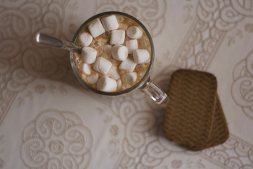 hot drink in a glass mug with cookies. cocoa with marshmellow. cup of coffee top view.