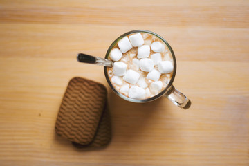 hot drink in a glass mug with cookies. cocoa with marshmellow. cup of coffee top view.