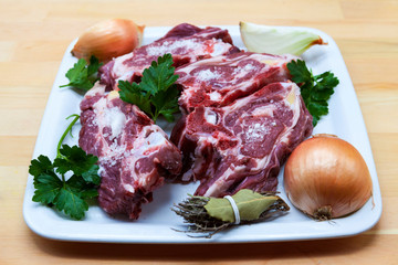 Pieces of fresh lamb on the plate . Delicious fat-tailed lamb with onion on the plate . Meat to be grilled.