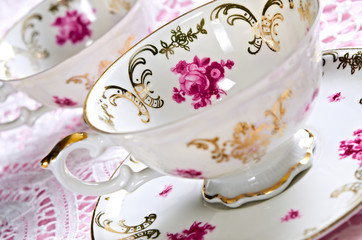 Antique porcelain tea cups on lace with shallow depth of field