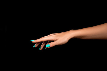 Studio shot of an unidentified woman's hand showing a gesture of fingers  pointing to something against a black background
