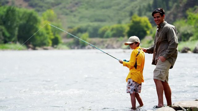 Confident dad and son using rod and reel casting line on Colorado River outdoors