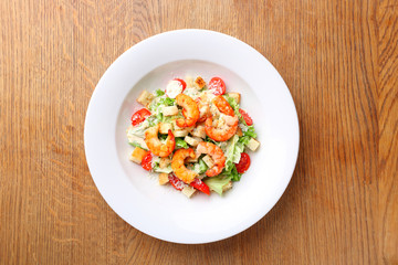 The best fresh salad of prawns in the white dish. Caesar salad with fried shrimps, tomatoes, cheese, lettuce. Healthy food concept. - Stock image