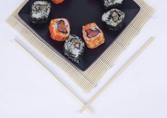different types of Maki sushi on a black plate
