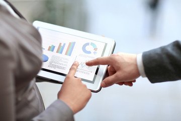close up. colleagues discuss financial data using a digital tabl