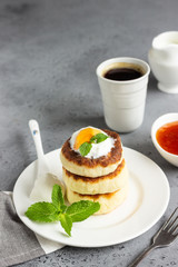 Cottage cheese pancakes or fritters with jam, natural yogurt or sour cream and mint. Traditional Ukrainian and Russian cuisine. Syrniki. Healthy and diet breakfast.