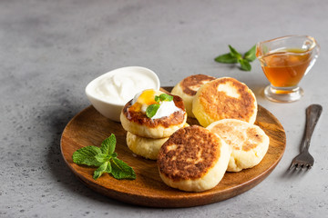 Cottage cheese pancakes or curd fritters decorated honey, sour cream and mint. Healthy and diet...