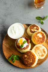 Cottage cheese pancakes or curd fritters decorated honey, sour cream and mint. Healthy and diet breakfast.