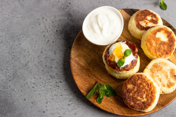 Cottage cheese pancakes or curd fritters decorated honey, sour cream and mint. Healthy and diet breakfast.
