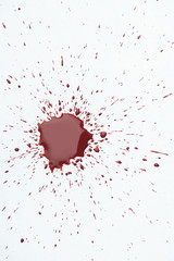 Fototapeta na wymiar top view of messy blood splash with small droplets on white surface