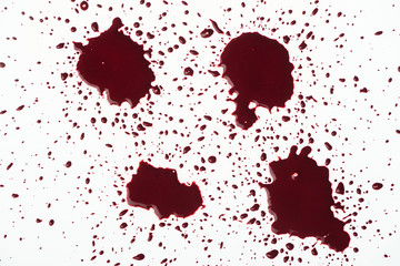 top view of blood splashes with small droplets on white surface