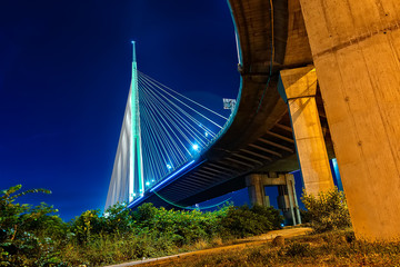 Belgrade, Serbia - 20 June, 2018: Side view of Ada bridge at night with reflection over Belgrade marina on Sava river