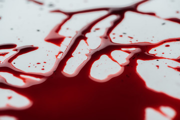 close-up shot of messy blood droplets on white surface