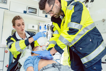 Sanitäter bei erster Hilfe am Krankenwagen