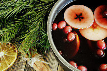 Christmas mulled wine with cranberries in a pot Winter warming drink with spices decorated with fir...