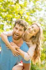 Mann trägt seine Frau auf dem Rücken, er ist ihr ein verlässlicher Partner