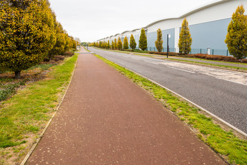 Fototapeta premium day view pedestrian footpath over a row of new built warehouses in industrial estate in england
