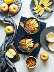 Cozy morning concept with turmeric amaranth porridge served with apples, flax seeds and almonds. Healthy plant based vegan breakfast. Flat lay