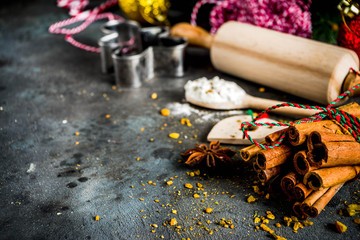 Christmas bakery background, with baking utensils, flour, spices and decorations, dark concrete table, copy space top view