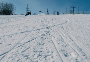 Teenage boy of 12 years sliding on a snowboard from snow descent next sky lift.