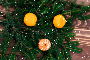 Christmas composition. Christmas pattern with tangerines, fir branch, red sock for gift and bells top view, flat, dark background, retro style, it is snowing. have toning. Copy space.