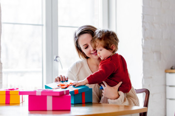 Mother and son holding a gift box for Christmas. At home