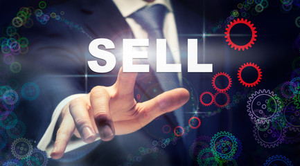 A businessman pressing a Sell business concept on a graphical display of cogs