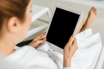 cropped shot of woman using digital tablet with blank screen in spa