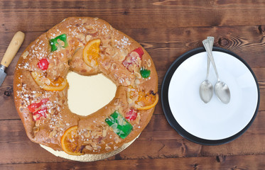 Kings cake and dishes on wooden background.
