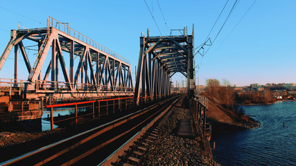 Obraz premium Railroad bridge rails train river beautiful evening cityscape sunset