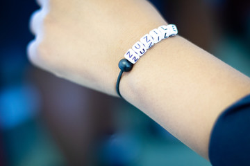 An arm displaying a letter bracelet 