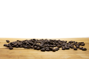 Pile of coffee bean on wooden table.