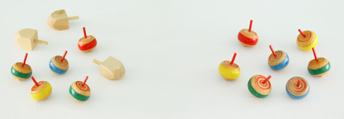 Image of jewish holiday Hanukkah with wooden dreidels colection (spinning top) over white background.