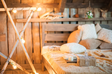 Scandinavian style bedroom interior under Christmas. Textural wooden bed in the style of New Year's Rustic decorated.