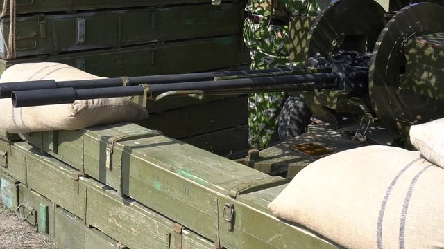 Closeup Of Muzzle Upon Firing. Military Camp With Weapons. Wooden Ammo Boxes