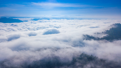 Aerial view above a Sea of fog coverage the mountains in the morning freshness.