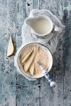Bowl of popped amaranth with milk and slices of pear