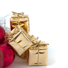 Merry Christmas, New Year, gifts in gold boxes, red Christmas balls are piled in the left corner. White background.