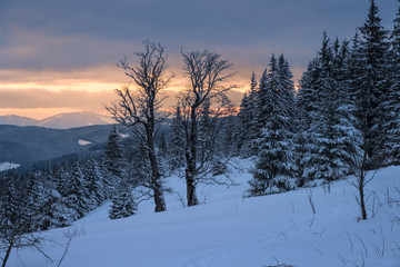 Winter landscape of a mountain range and valley in winter at sunset.