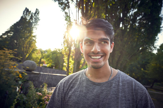 Portrait of a young man in a park at sunset, smiling