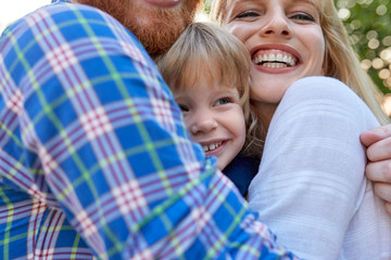 Happy parents hugging her daughter outdoors