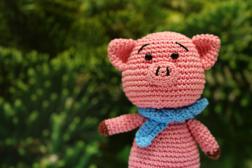 Knitted toy piggy on christmas decorations background. Chinese new year of the Pig, symbol 2019, Zodiac sign for greetings card