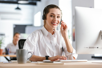 Happy young woman wearing microphone headset