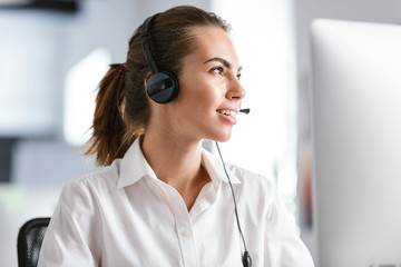 Smiling young woman wearing microphone headset