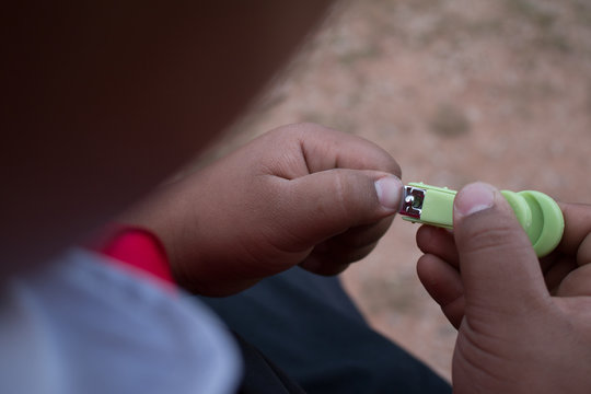 Closeup Of Man Trims His Fingernails Using A Metallic Pair Of Nail Clippers