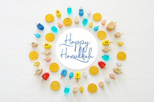 Image of jewish holiday Hanukkah with wooden dreidels colection (spinning top) and chocolate coins over white background.