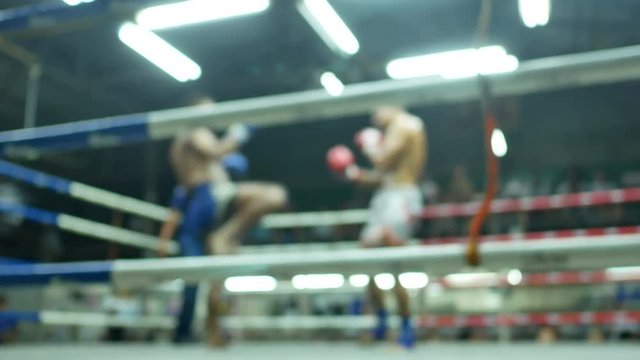 asian men thai boxing are punch and kick together with committee on canvas boxing stadium