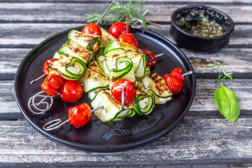 Grilled vegetarian grill skewers, tomato, sheep cheese and zucchini slices, rosemary garlic oil