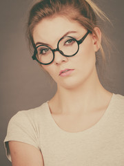Bored focused teenage woman wearing eyeglasses