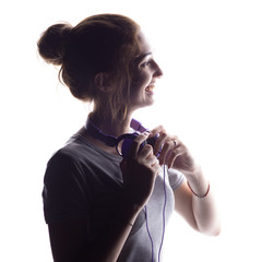 silhouette of a happy girl listening to music with headphones, woman sincerely laugh on a white isolated background